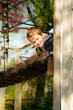 Junge schaut von einer Holzbrücke runter