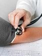 Arzt misst den Blutdruck und Puls bei Patientin