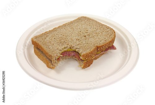 Photo: Bitten corned beef sandwich on paper plate Bitten corned beef sandwich on paper plate