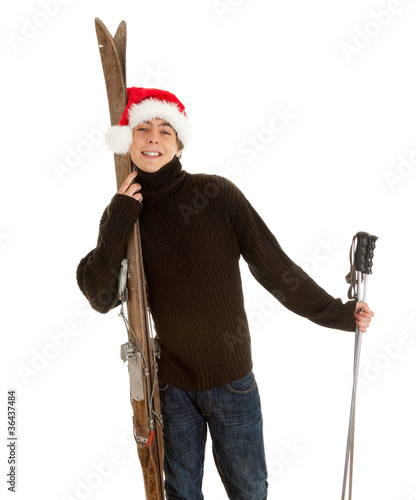Photo: smiling Christmas young man with old wooden ski smiling Christmas young man with old wooden ski