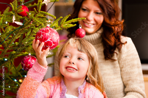 Photo: Familie schmückt Weihnachtsbaum Familie schmückt Weihnachtsbaum