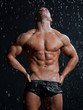 Muscle wet sexy young naked man posing under the rain in studio Muscle wet sexy young naked man posing under the rain in studio