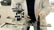 Lab Tech Looks into Microscope