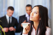 pensive asian woman with her business partners on the background