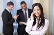 young happy asian woman on phone with her business partners