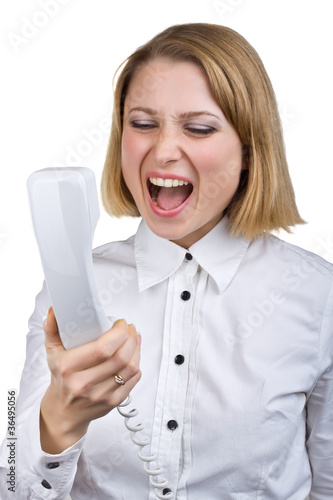 Photo: Business woman shouting into the telephone receiver Business woman shouting into the telephone receiver
