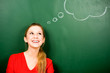 Woman standing next to thought bubble on blackboard