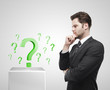 Young  businessman look at the green question marks