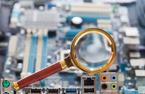 Photo: Magnifying glass and circuit board Magnifying glass and circuit board
