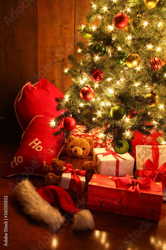 Photo: Brightly lit Christmas tree with gifts Brightly lit Christmas tree with gifts