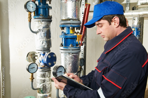 Photo: heating engineer repairman in boiler room heating engineer repairman in boiler room