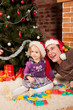 Little girl play with her dad  near Christmas tree