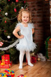 Preaty little girl  smiling near the Christmas tree