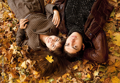 Photo: Couple lying in the park in fall Couple lying in the park in fall