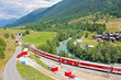 red train in high mountain valley in switzerland alps