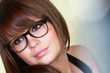 Jeune fille pensive portant des lunettes