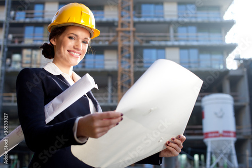 Photo: Young female architect/construction engineer at a construction s Young female architect/construction engineer at a construction s