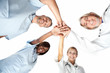 Group of doctors joining hands with low angle view