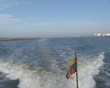 Lithuanian tricolor flag flying in wind at end of boat. Lithuanian tricolor flag flying in wind at end of boat.