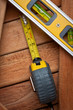 Spirit level and measuring tape over wooden boards