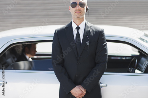 Photo: Security guard standing by car Security guard standing by car
