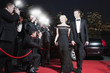 Celebrities posing for paparazzi on red carpet