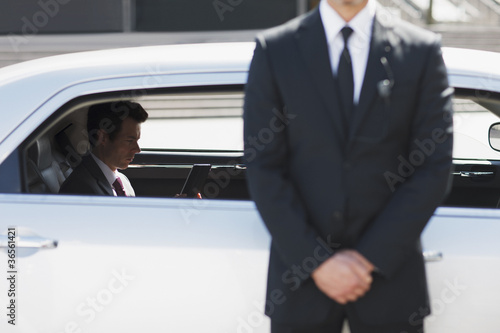 Photo: Bodyguard protecting politician in backseat of car Bodyguard protecting politician in backseat of car