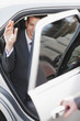 Politician waving and emerging from car