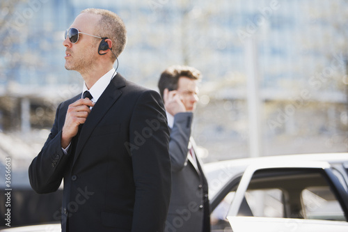 Photo: Bodyguard talking into earpiece Bodyguard talking into earpiece