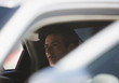 Politician sitting in backseat of car