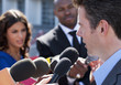 Photo: Politician talking into reporters' microphones Politician talking into reporters' microphones