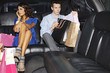 Couple with shopping bags in backseat of limo