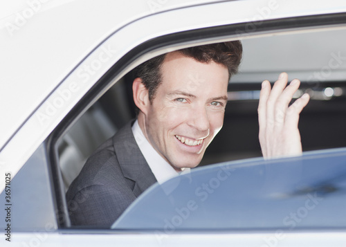 Photo: Politician waving from backseat of car Politician waving from backseat of car