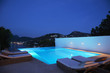 Pool with lounge chairs at night