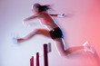 Blurred view of runner jumping hurdles