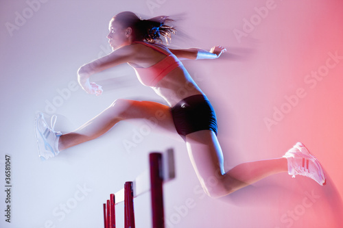 Photo: Blurred view of runner jumping hurdles Blurred view of runner jumping hurdles