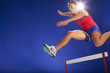 Athlete jumping over hurdles