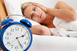 Schlaflos mit Uhr in der Nacht.