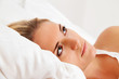 Frau liegt wach im Bett. Schlaflos