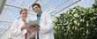 Scientist examining clipboard in greenhouse