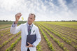 Scientist examining liquid in test tube outdoors