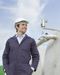 Worker standing by tank outdoors