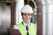 Businessman in safety gear examining pipes