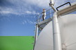 Scientist standing on walkway on tanks