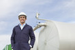 Worker standing by tanks outdoors