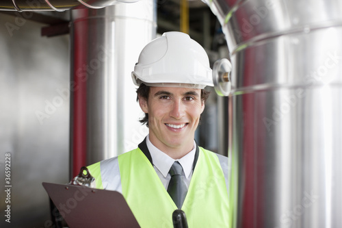 Photo: Businessman in safety gear examining pipes Businessman in safety gear examining pipes