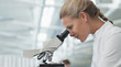 Scientist using microscope in lab