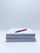 Red pencil on stack of paper