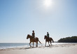 Girls riding horses on beach