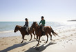 Girls riding horses on beach